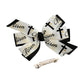 Hair bow with 'He is Risen' text and crosses, accompanied by a hair clip on a white background.