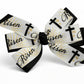 Bow with 'Risen' and cross designs on a white background