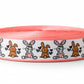 Roll of pink ribbon with cartoon bunny designs on a white background